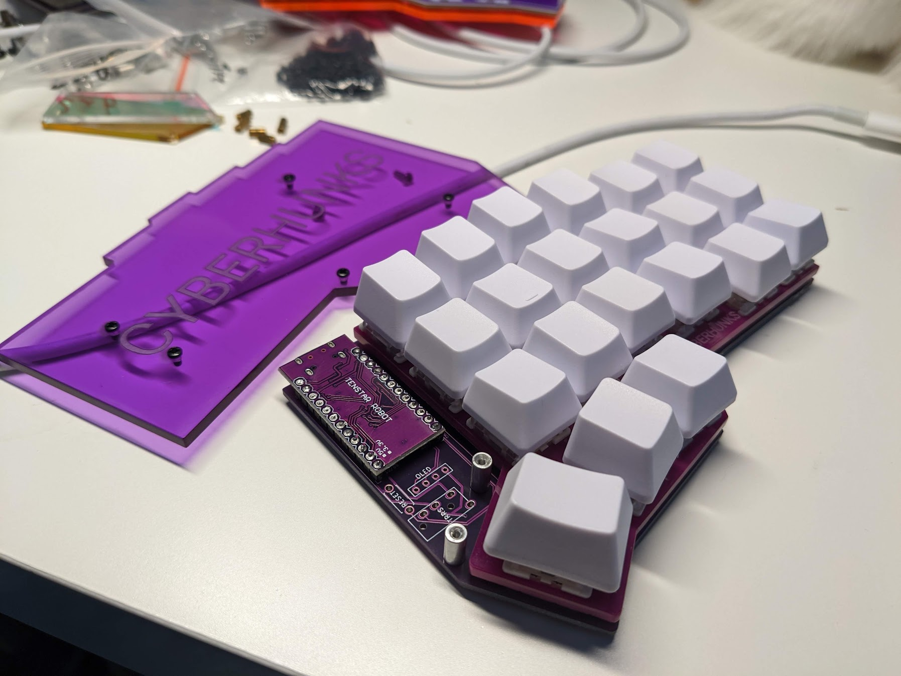 Purple Cyberhunks Corne keyboard with white keycaps and acrylic plate